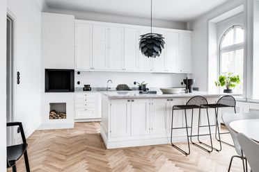 Vitt kök i både modernt och lantlig stil med köksö