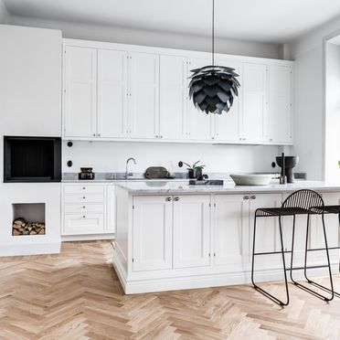 Vitt kök i både modernt och lantlig stil med köksö